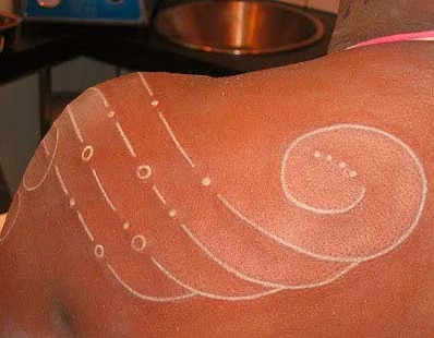 Fine line work white ink tattoo on dark skin