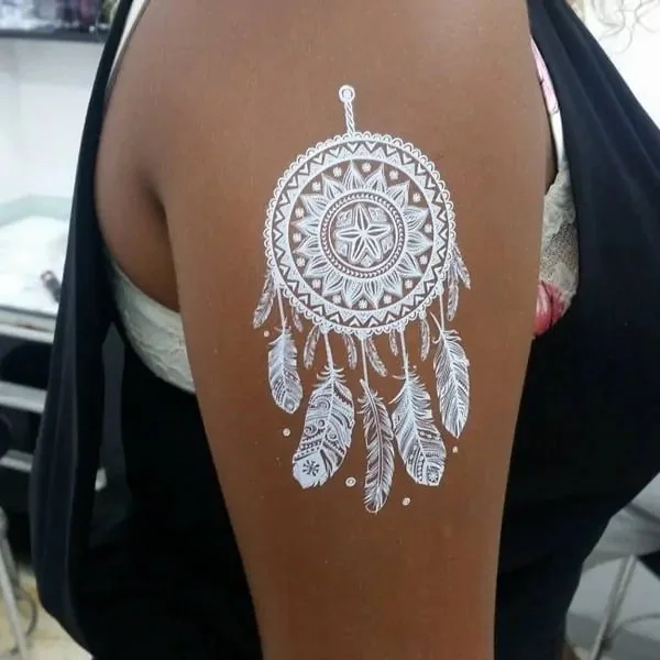 Lace-like designs white ink tattoo on dark skin
