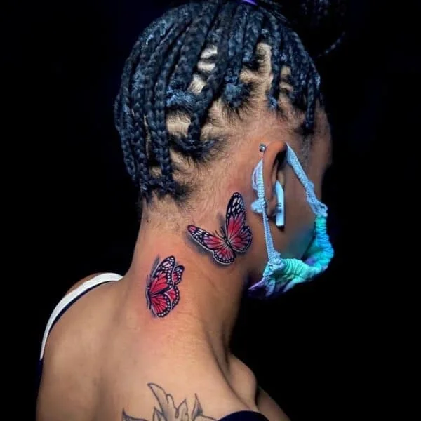 Red ink butterfly tattoo on dark skin